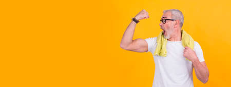 surprised senior man of his biceps muscleの写真素材