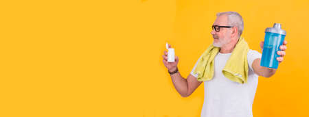 attractive senior man with bottle of vitamins or food supplements for sports. health and sport conceptの写真素材