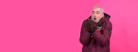 attractive senior man wearing anorak and scarf with backgroundの写真素材