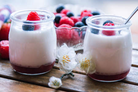 yoghurt with raspberries and blueberries on wooden backgroundの写真素材