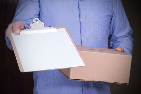 person delivers package to home with delivery note to sign. Friendly worker, high quality delivery serviceの写真素材