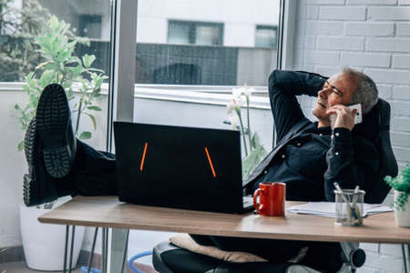 businessman in office talking on the phoneの写真素材