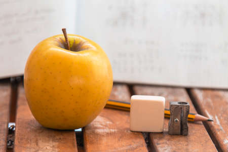 books, apple and medical mask. back to school concept in the new normalの写真素材