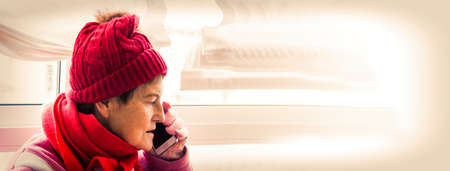 senior woman with disposable surgical mask placing christmas decorationsの写真素材
