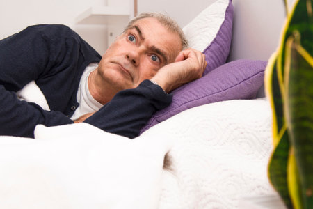 man in bed with insomnia or sleeplessの写真素材