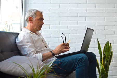 middle-aged man with laptop and credit cardの写真素材