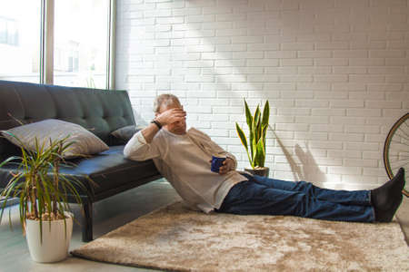 lonely, burdened and sad man at homeの写真素材