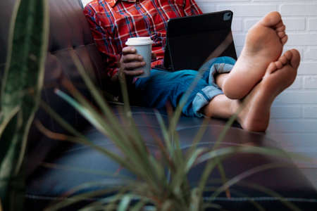relaxed man having coffee and looking at mobile phone