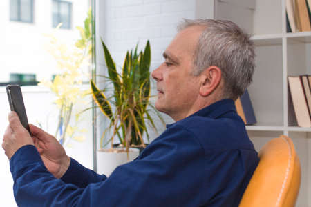 man at home with mobile phone or smartphoneの写真素材