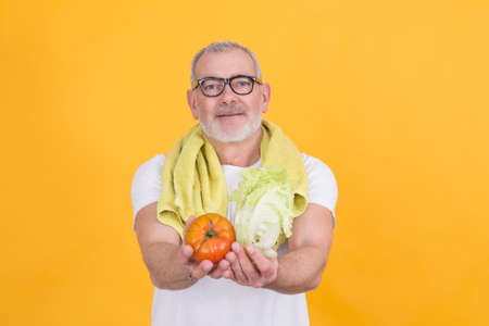 Middle-aged athlete man showing healthy food. diet and eating conceptの写真素材
