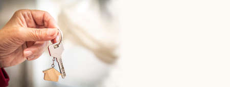 Woman holding house key in hand. Mortgage loan approval home loan and insurance concept.