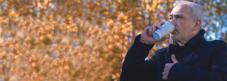portrait of man with coat in autumnの写真素材