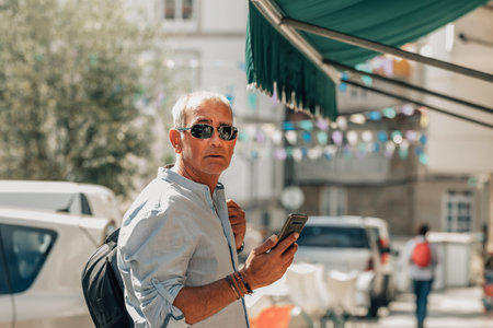 tourist man with backpack and mobile phone on the streetの写真素材