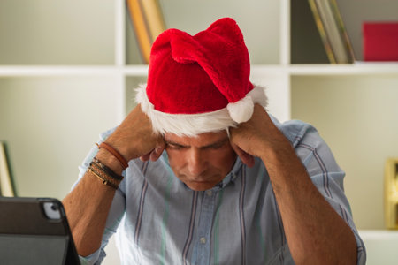 man with santa hat in the office celebrating christmas with victory gestureの写真素材