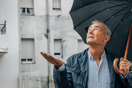 middle-aged man with umbrella in the streetの写真素材