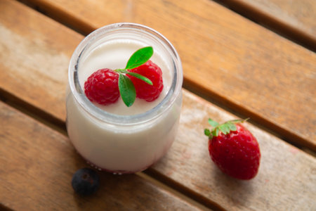 Greek yogurt with blackberries and strawberries on woodの写真素材