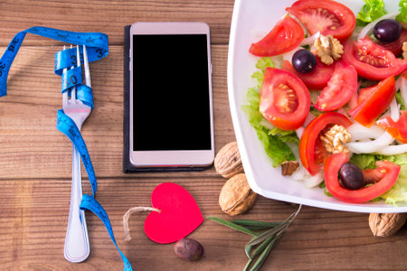 phone, salad and tape measure, concept of diet and appの写真素材