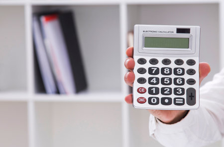 hand holding a calculator with copy spaceの写真素材