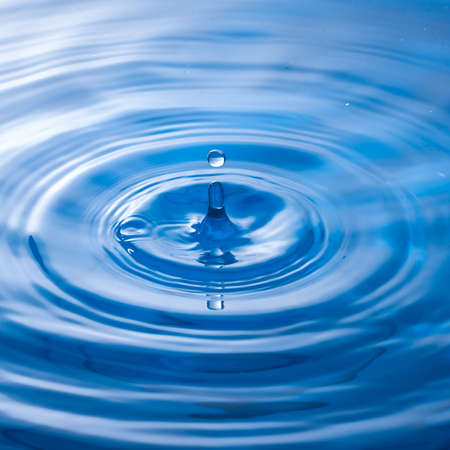 a water drop impact with water surface, causing rings on the surface.の写真素材