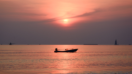 silhouette boat on a sea at sunsetの写真素材