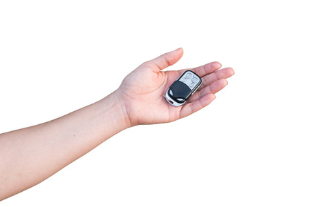 Hand holding car key isolated on white background