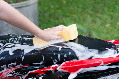 Female hand washing a motorcycle.の写真素材