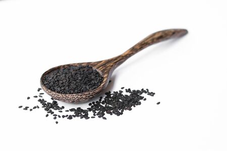 black sesame on wooden spoon isolated on whiteの写真素材