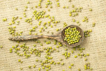 mung beans over wooden spoon on jute bag backgroundの写真素材