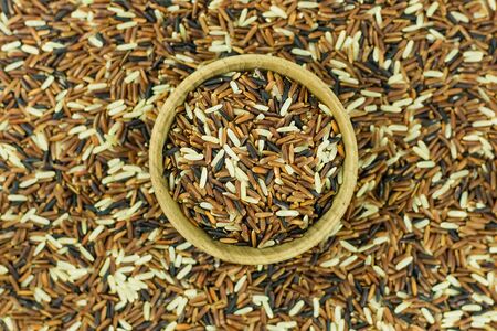 wood bowl and brown rice backgroundの写真素材