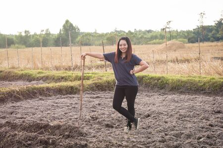 Woman farmer holding spade at field in nakhon phanom,Thailandの写真素材