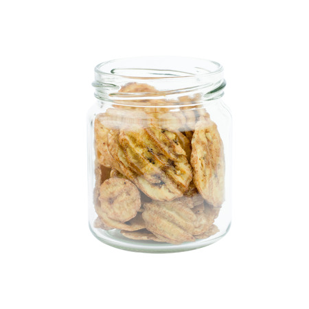 Dried banana slices in Glass bottles isolated on white backgroundの写真素材