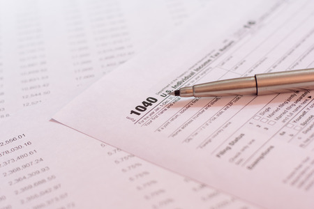 US tax form with pen and calculator selective focus / taxation conceptの写真素材
