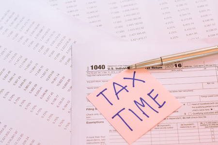 Tax Time written on pink sticker note with on U.S. tax formの写真素材