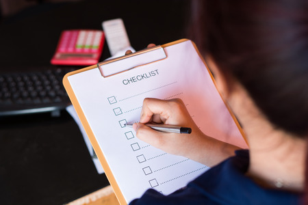 image of businessfemale preparing checklist at office deskの写真素材