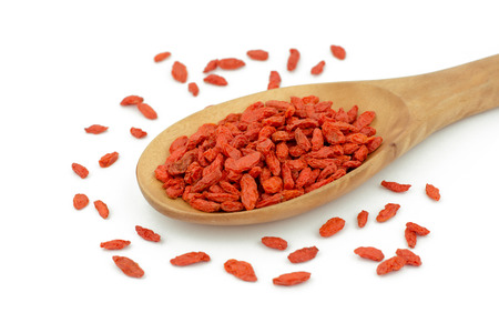 goji berries in wood spoon on white backgroundの写真素材