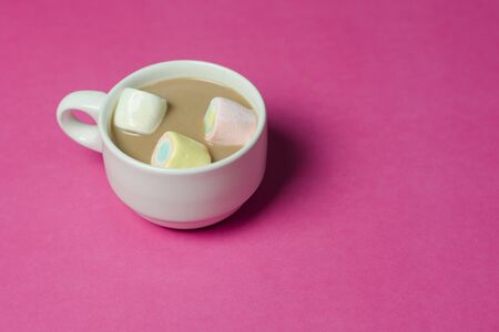 hot chocolate with marshmallows in a ceramic cup on pink paper backgroundの写真素材