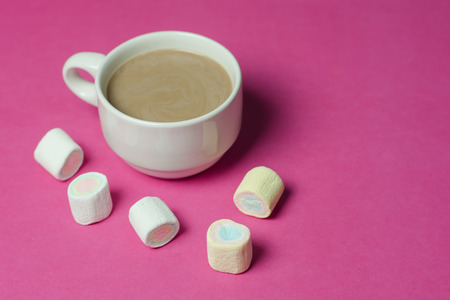 hot chocolate with marshmallows in a ceramic cup on pink paper backgroundの写真素材