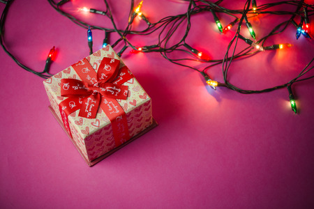 gift boxes with red ribbons. Pink paper background. Gifts for Christmas or a birthday.の写真素材