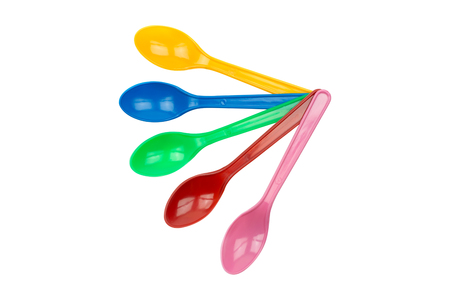 colorful plastic spoons for party isolated on whiteの写真素材