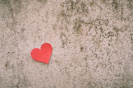 red paper heart shape on concrete backgroundの写真素材