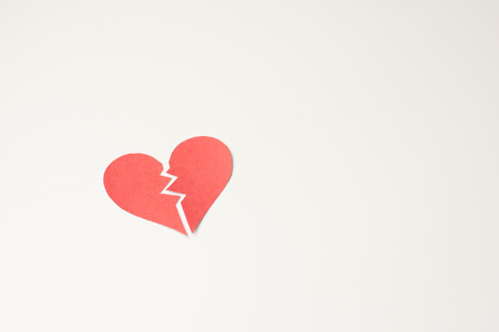 Red paper broken heart on white backgroundの写真素材