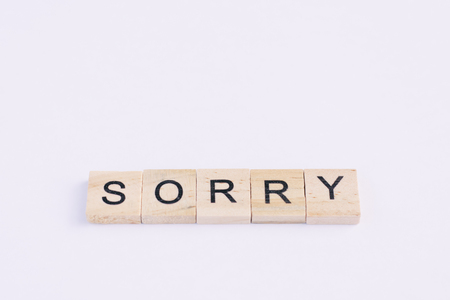 Text wooden blocks spelling the word sorry on white backgroundの写真素材