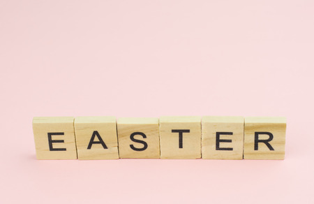Text wooden blocks spelling the word easter on pink backgroundの写真素材