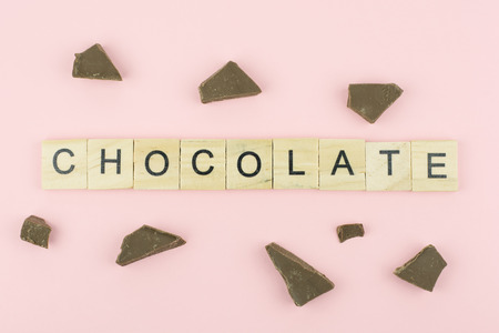 Text wooden blocks spelling the word chocolate on pink backgroundの写真素材