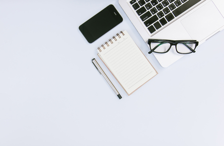 White office desk table with a lot of things on it. Top view with copy space.の写真素材