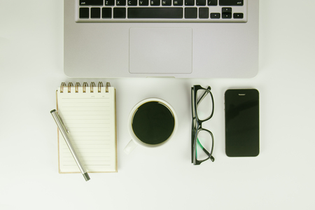 White office desk table with a lot of things on it. Top view with copy space.の写真素材
