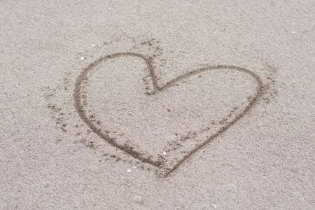Heart drawn on sand on the beach. Abstract of this image is love.の写真素材