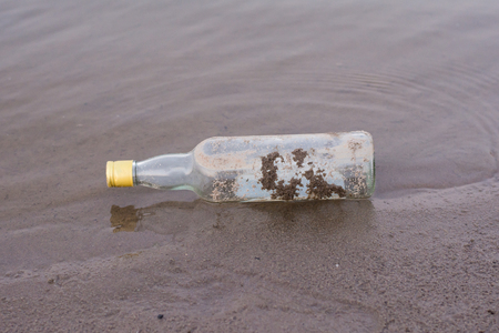 bottles and garbage waste on the shore of a river.の写真素材