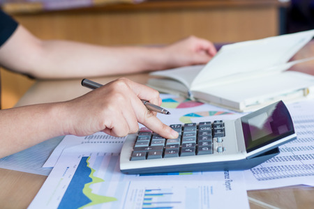 woman hand using calculator and writing make note with calculateの写真素材
