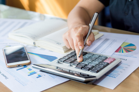 woman hand using calculator and writing make note with calculateの写真素材